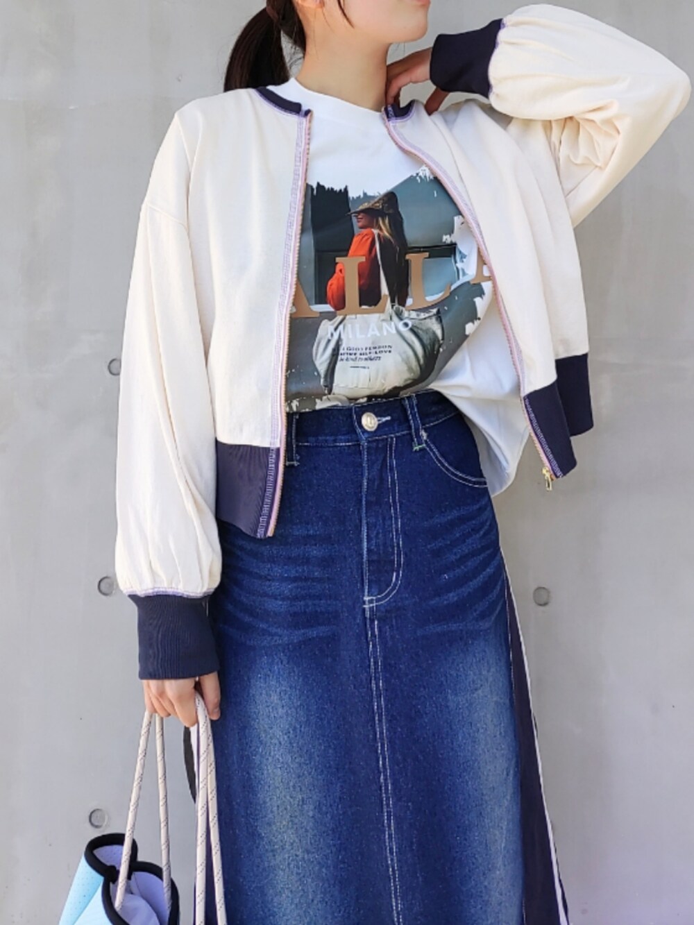 ブルー系のトートバッグ、ブルー系のデニムスカート、ホワイト系のスニーカーを着用したレディースの冬コーディネートの4枚目の写真