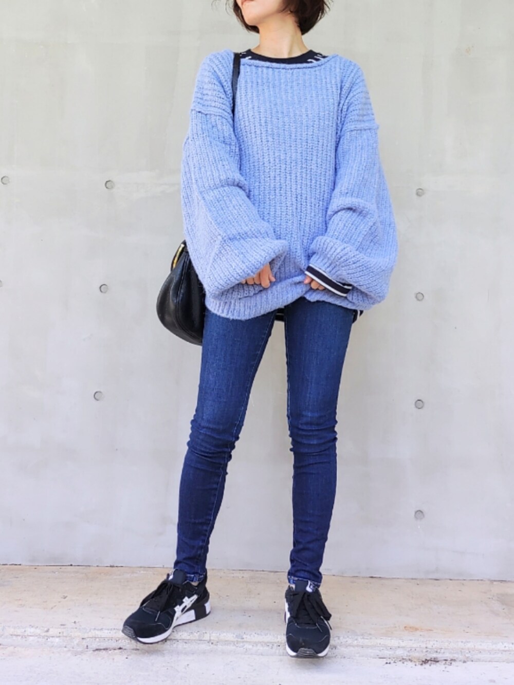 ブルー系のデニムパンツ、ブラック系のスニーカー、ブルー系のTシャツ/カットソーを着用したレディースの秋コーディネートの3枚目の写真