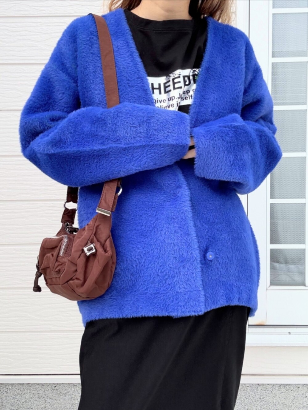 ブラック系のスカート、ブルー系のカーディガン/ボレロ、ブラック系のTシャツ/カットソーを着用したレディースの秋コーディネートの5枚目の写真