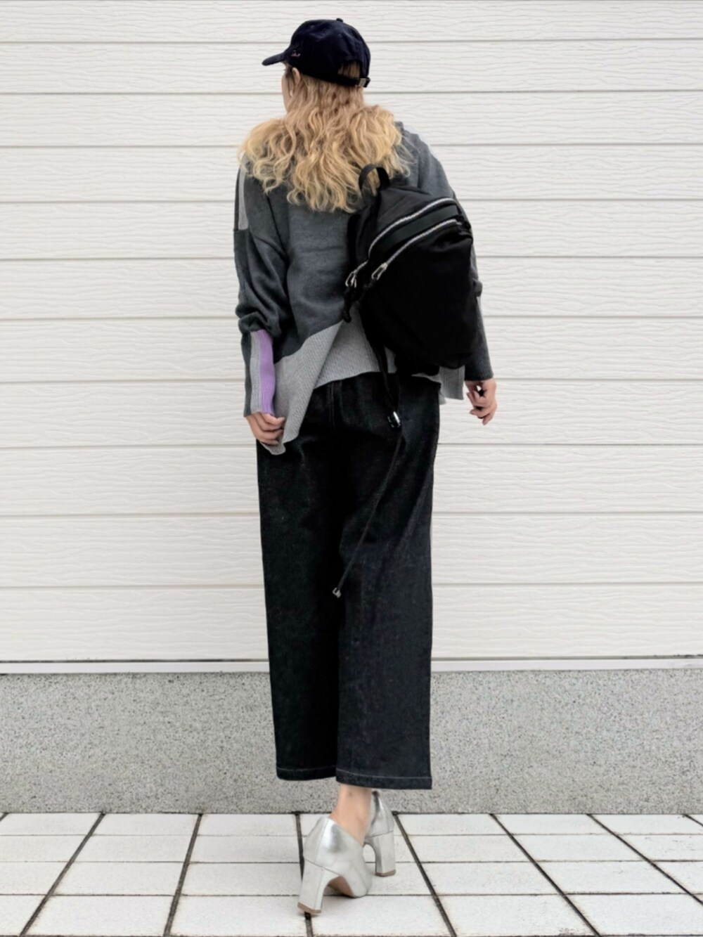 ブラック系のデニムパンツ、グレー系のニット/セーター、ブラック系のバックパック/リュックを着用したレディースの秋コーディネートの3枚目の写真