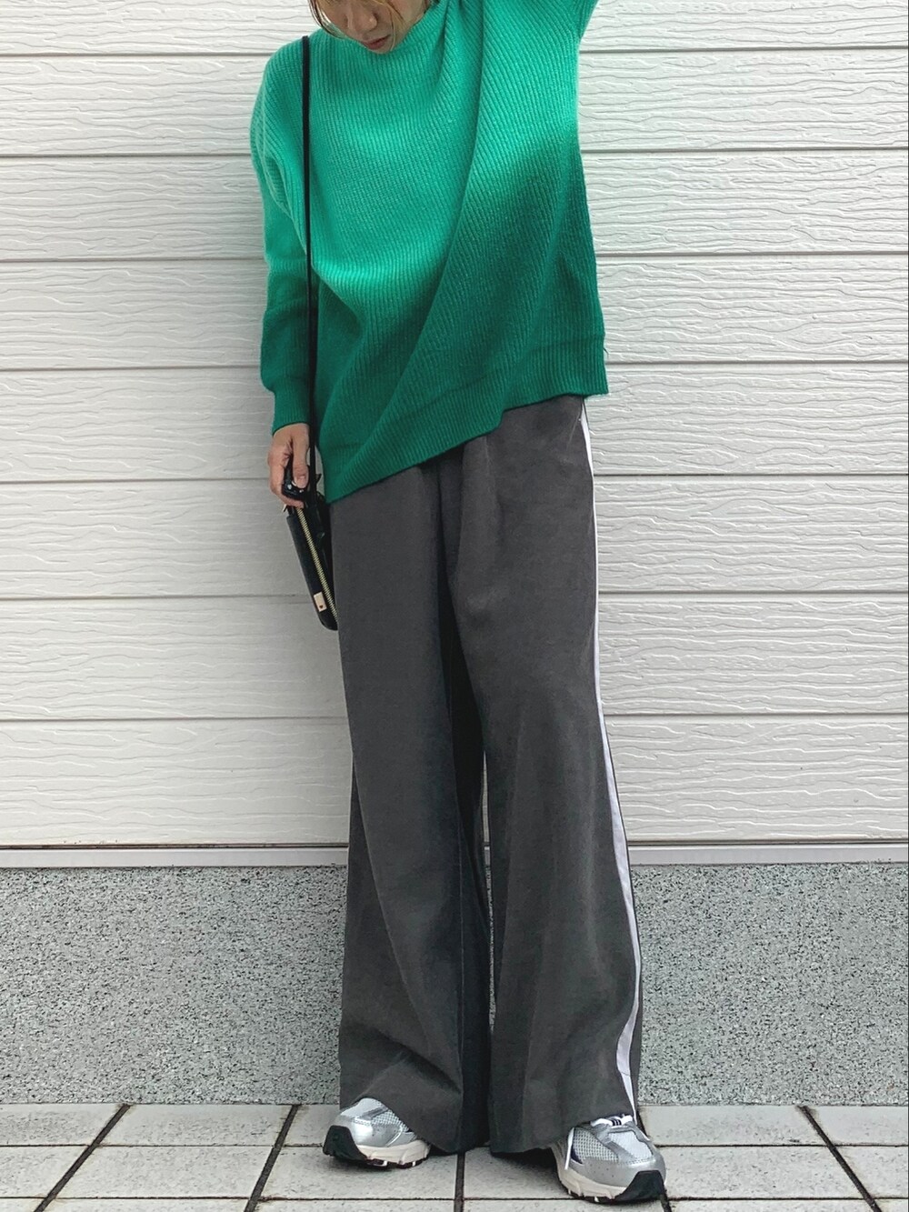 グリーン系のニット/セーター、グレー系のその他パンツ、シルバー系のスニーカーを着用したレディースの冬コーディネートの2枚目の写真