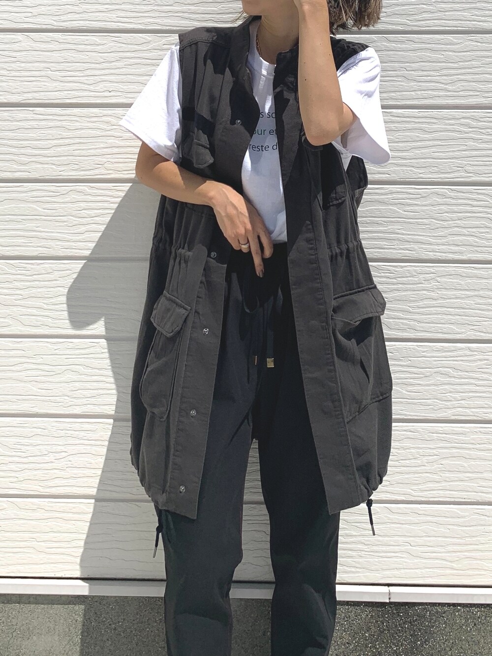 ブラック系のその他パンツ、ホワイト系のTシャツ/カットソー、ブラック系のベストを着用したレディースの夏コーディネートの2枚目の写真
