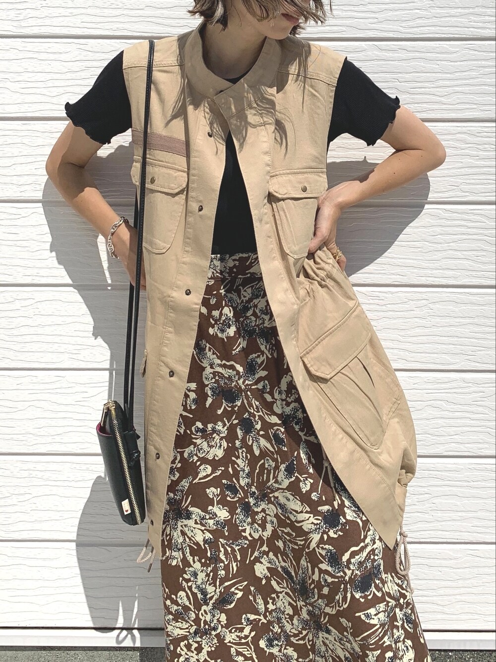 ベージュ系のベスト、ブラック系のTシャツ/カットソー、ブラック系のスニーカーを着用したレディースの夏コーディネートの2枚目の写真