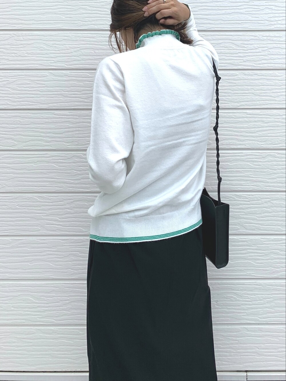 ブルー系のデニムパンツ、ブラック系のショルダーバッグ、ブラック系のスニーカーを着用したレディースの夏コーディネートの2枚目の写真