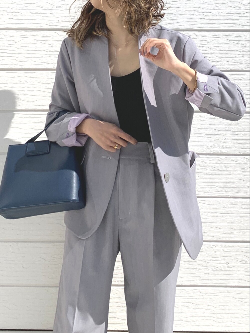 グレー系のその他パンツ、グレー系のノーカラージャケット、ブルー系のハンドバッグを着用したレディースの冬コーディネートの3枚目の写真