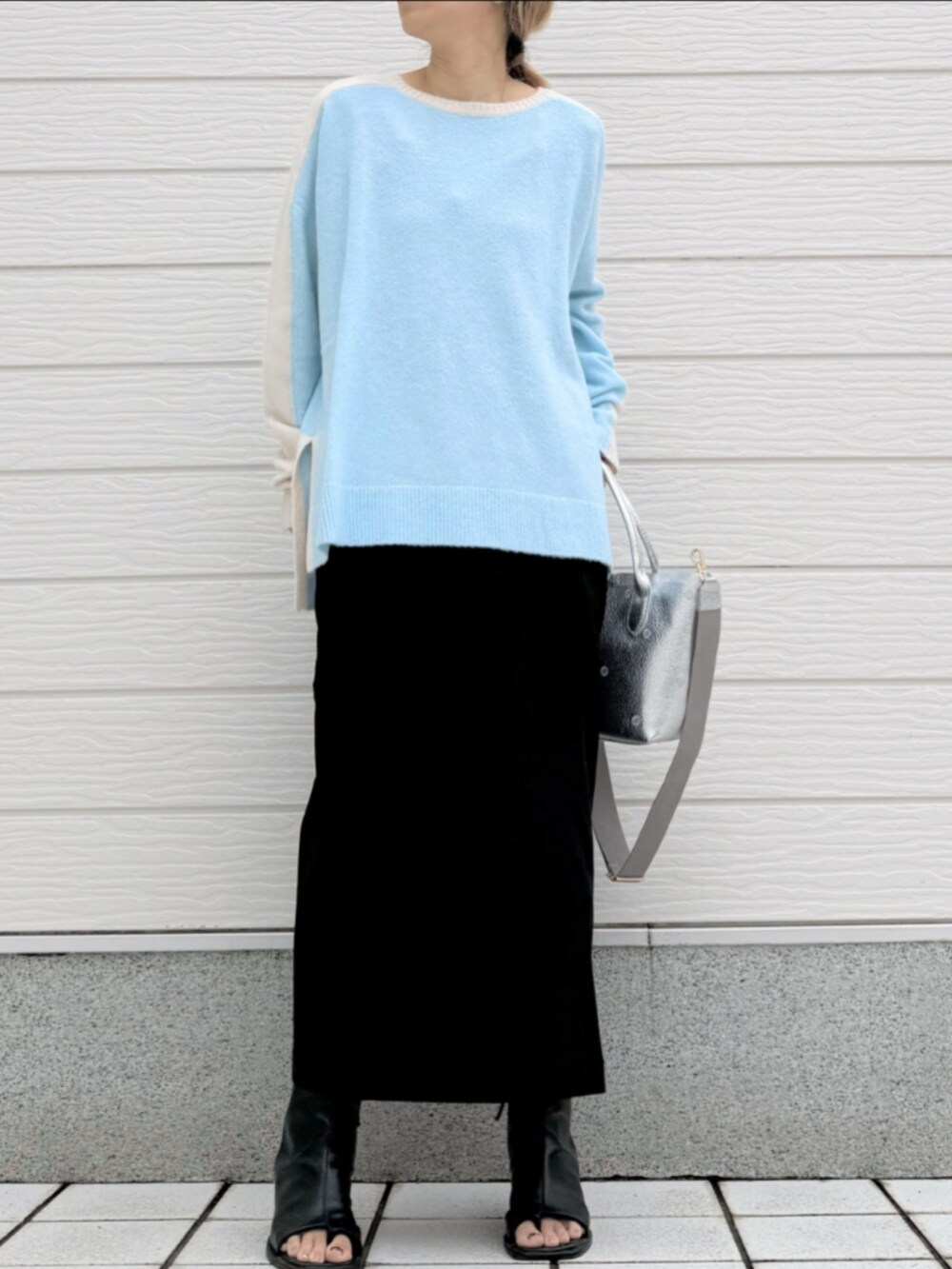 ブラック系のサンダル、ブラック系のスカート、シルバー系のトートバッグを着用したレディースの冬コーディネートの2枚目の写真