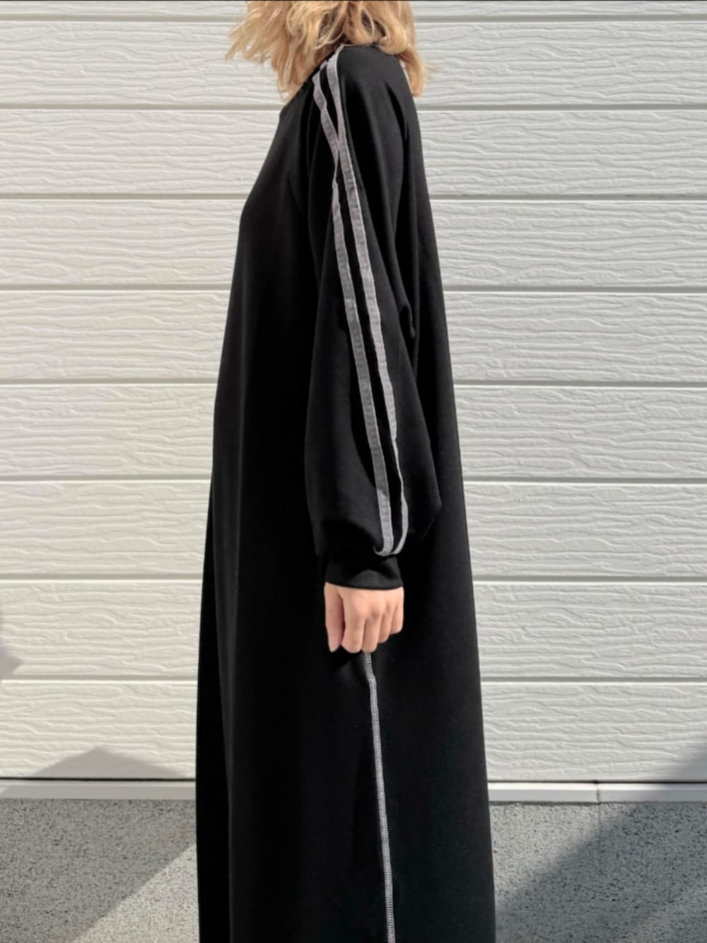 ホワイト系のスニーカー、ブラック系のワンピース、グレー系のトートバッグを着用したレディースの秋コーディネートの5枚目の写真