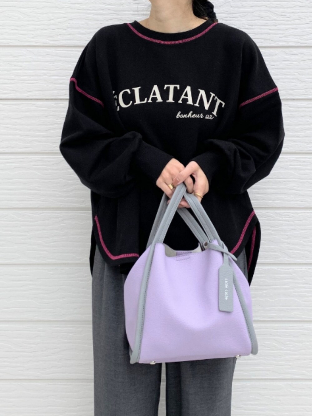 グレー系のスラックス、パープル系のトートバッグ、ブラック系のスウェットを着用したレディースの秋コーディネートの3枚目の写真