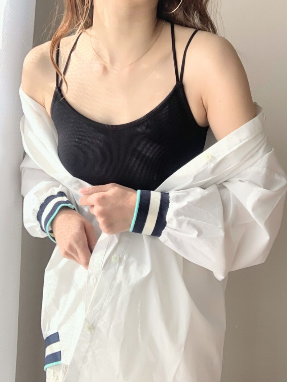 ブルー系のデニムパンツ、ホワイト系のシャツ/ブラウス、ブラック系のキャミソールを着用したレディースの冬コーディネートの4枚目の写真