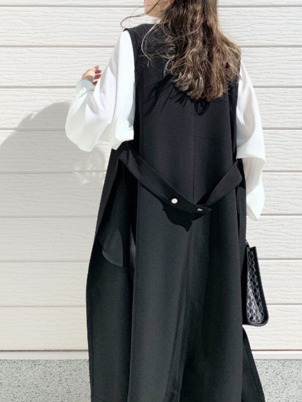 ブラック系のショルダーバッグ、グレー系のスラックス、ホワイト系のシャツ/ブラウスを着用したレディースの春コーディネートの3枚目の写真