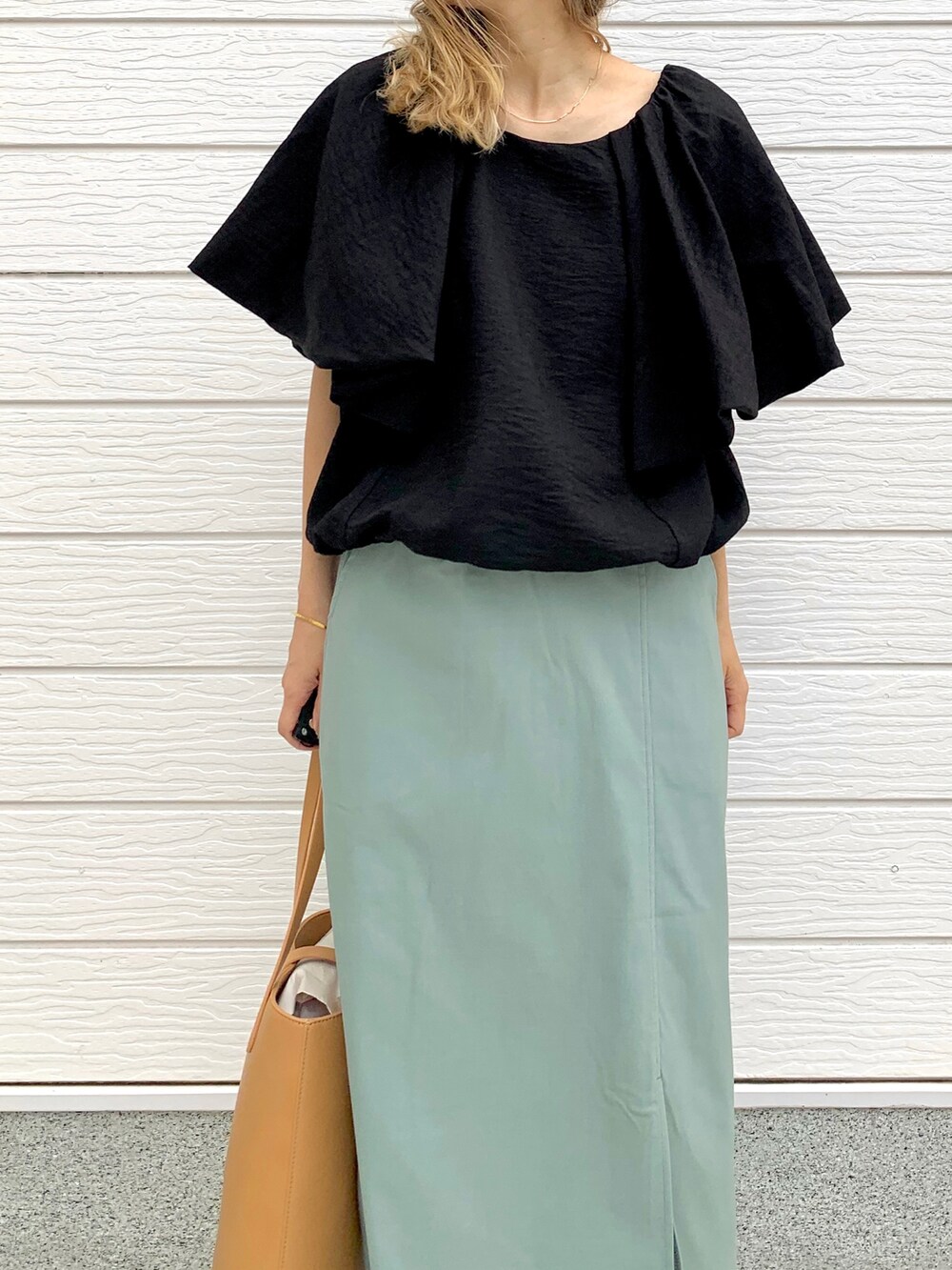 グリーン系のスカート、ベージュ系のトートバッグ、ブラック系のシャツ/ブラウスを着用したレディースの春コーディネートの3枚目の写真