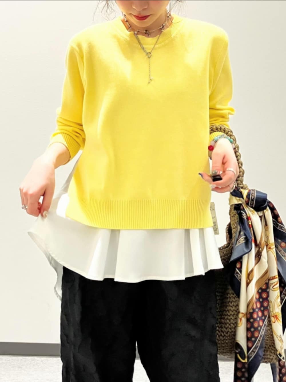 ブラック系のその他パンツ、ベージュ系のトートバッグ、イエロー系のニット/セーターを着用したレディースの春コーディネートの4枚目の写真