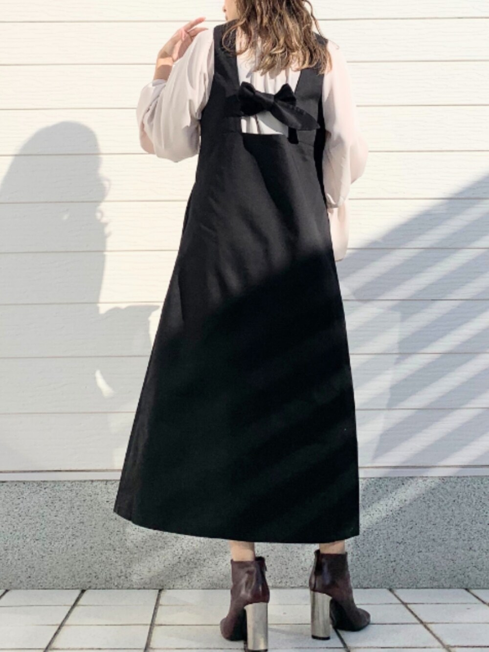 ブラウン系のブーツ、ベージュ系のシャツ/ブラウス、ブラック系のジャンパースカートを着用したレディースの冬コーディネートの3枚目の写真