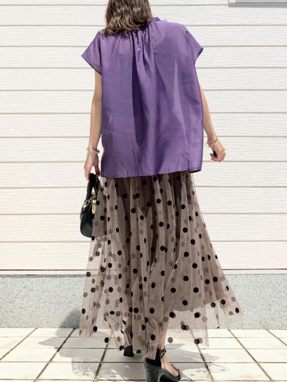 ブラウン系のスカート、ブラック系のショルダーバッグ、パープル系のシャツ/ブラウスを着用したレディースの春コーディネートの3枚目の写真