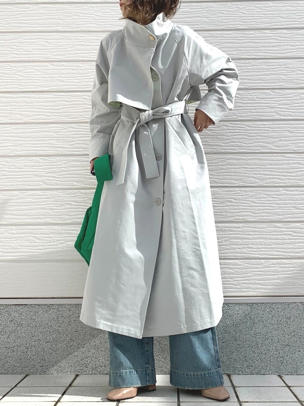 ブルー系のデニムパンツ、グリーン系のショルダーバッグ、ブラック系のニット/セーターを着用したレディースの冬コーディネートの2枚目の写真