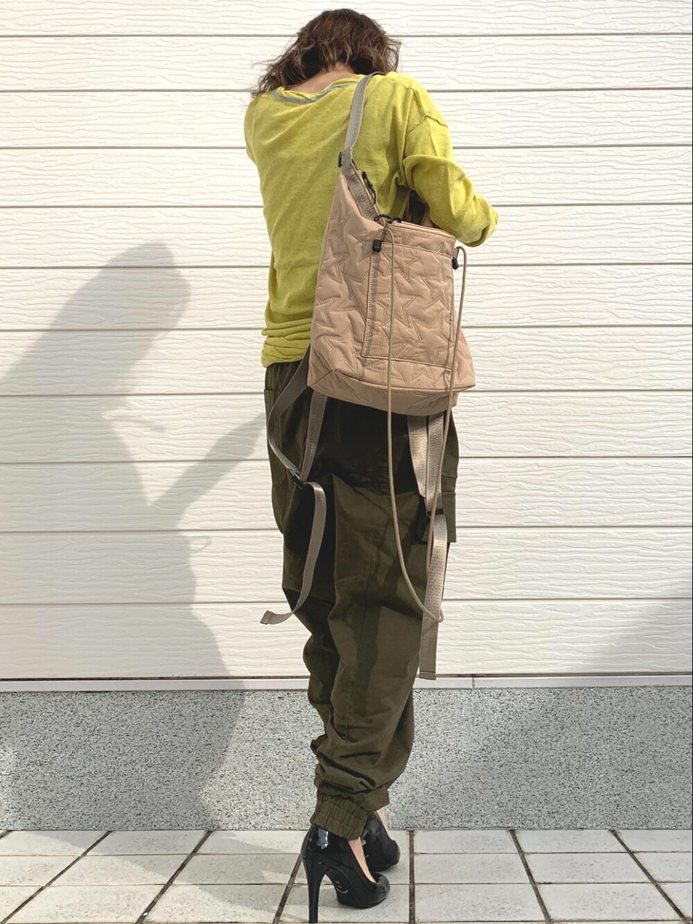 グリーン系のその他パンツ、ベージュ系のショルダーバッグ、グリーン系のニット/セーターを着用したレディースの冬コーディネートの2枚目の写真