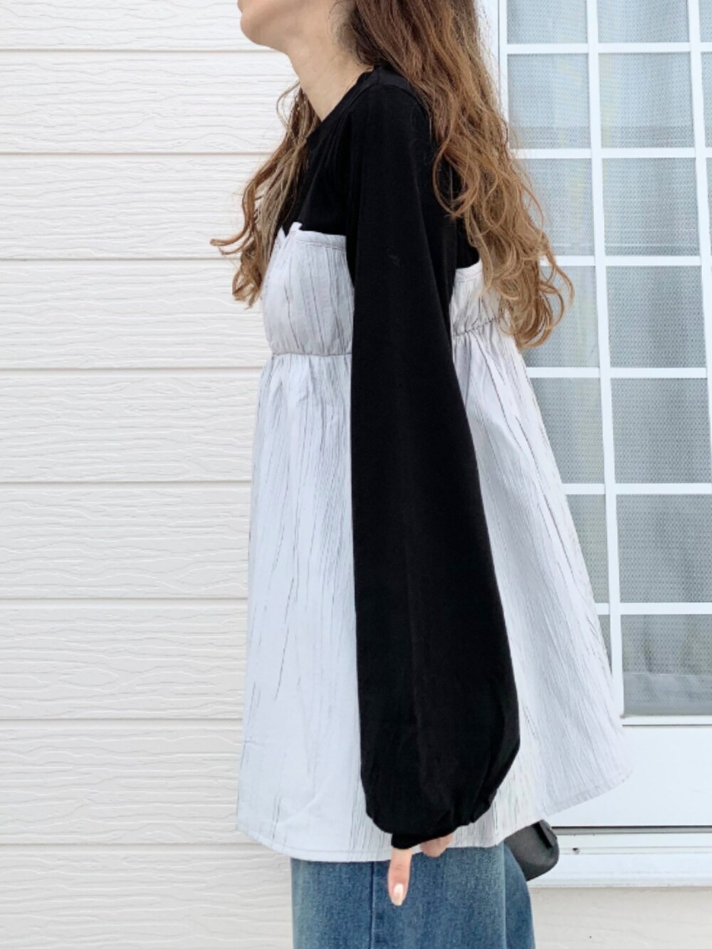 ブルー系のデニムパンツ、ホワイト系のスニーカー、ブラック系のTシャツ/カットソーを着用したレディースの夏コーディネートの5枚目の写真