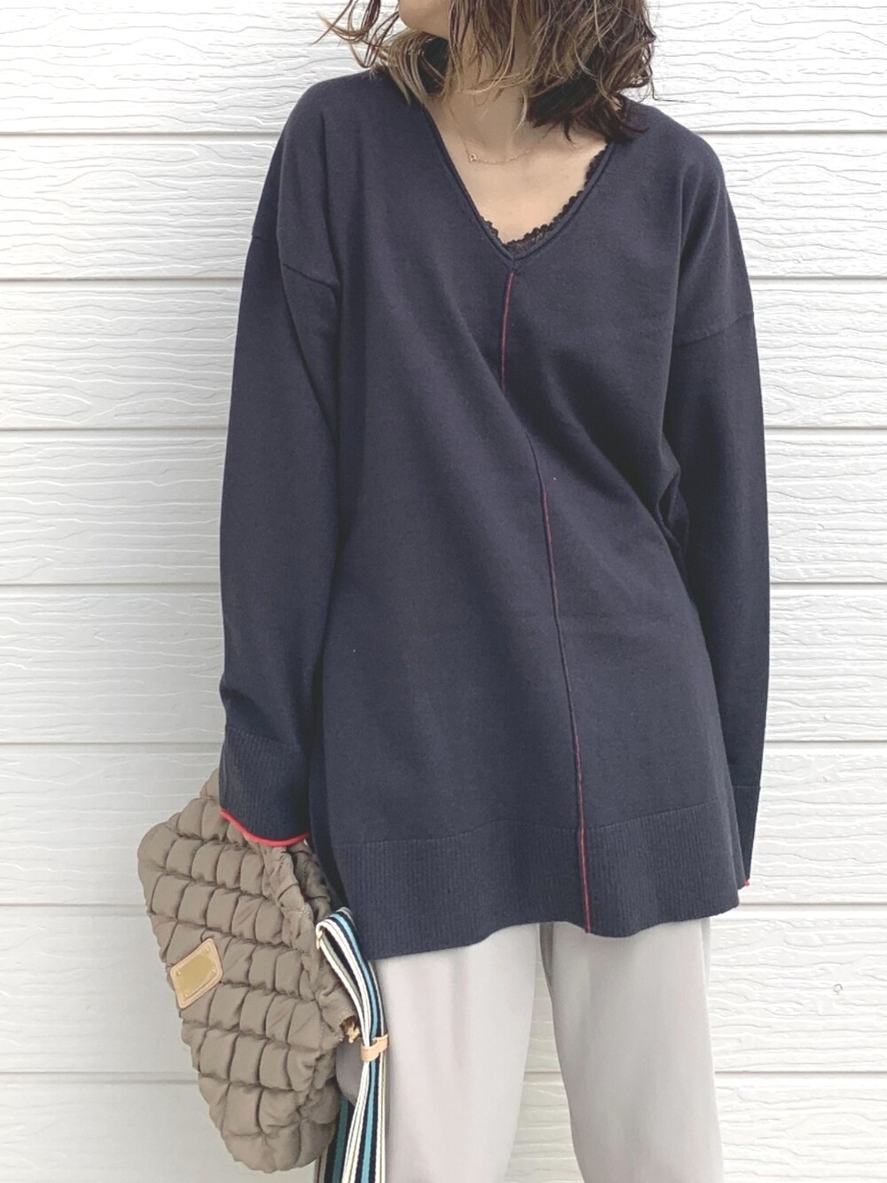 ホワイト系のその他パンツ、グレー系のニット/セーター、ベージュ系のショルダーバッグを着用したレディースの冬コーディネートの3枚目の写真