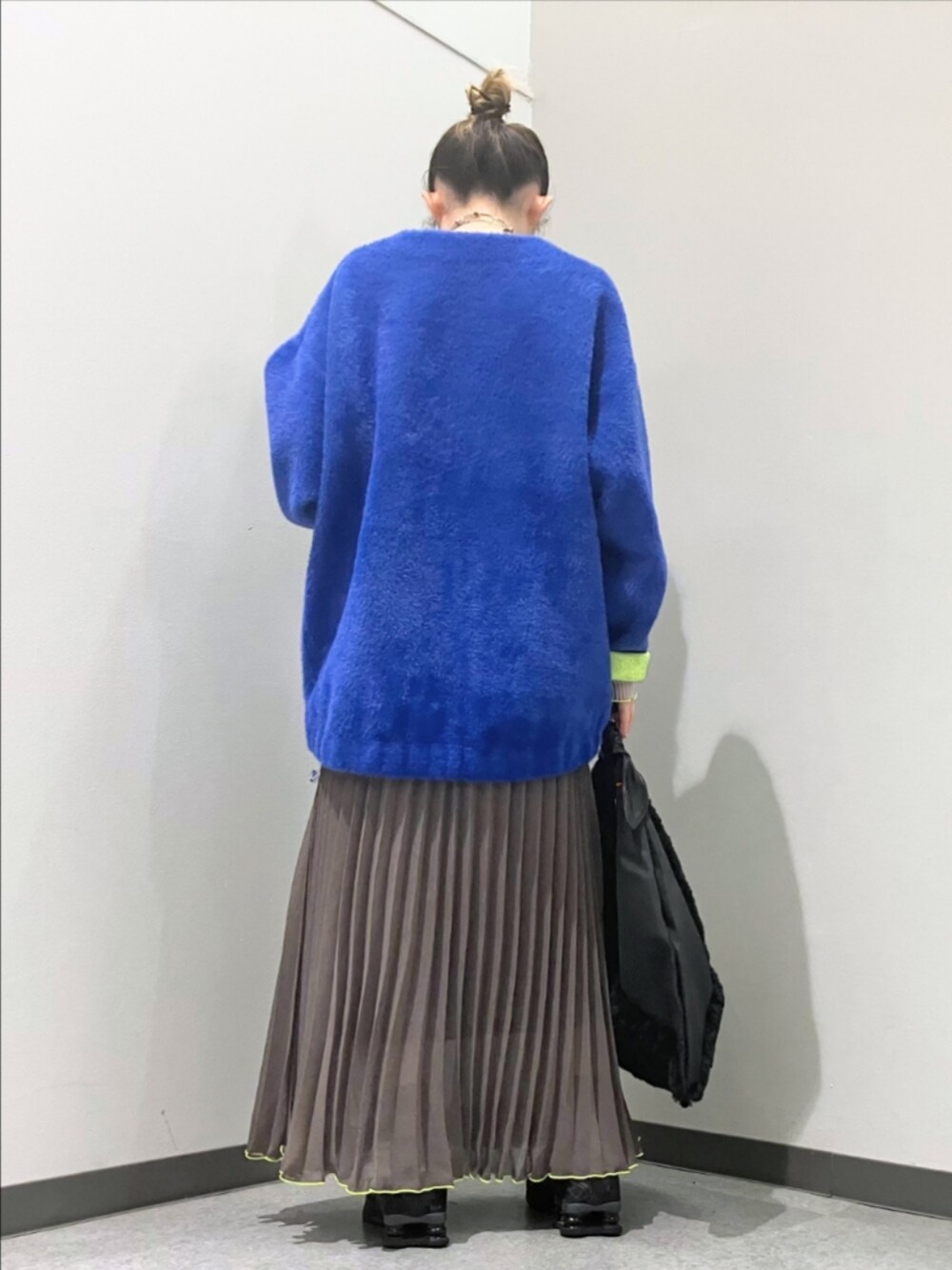 グリーン系のスカート、ブルー系のカーディガン/ボレロ、グレー系のTシャツ/カットソーを着用したレディースの秋コーディネートの2枚目の写真