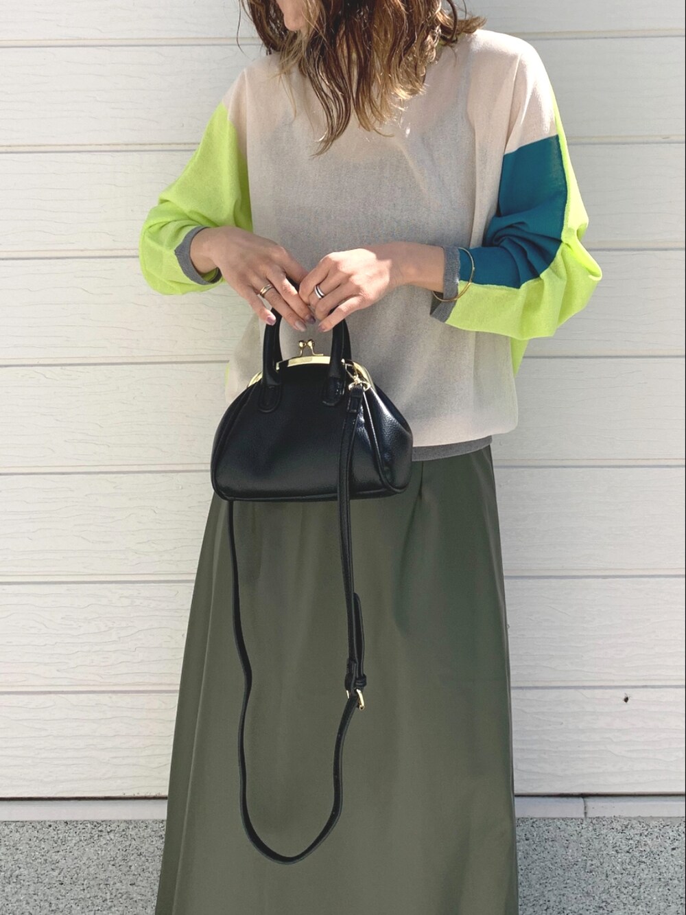 ブラック系のショルダーバッグ、グリーン系のスカート、グリーン系のカーディガン/ボレロを着用したレディースの春コーディネートの3枚目の写真
