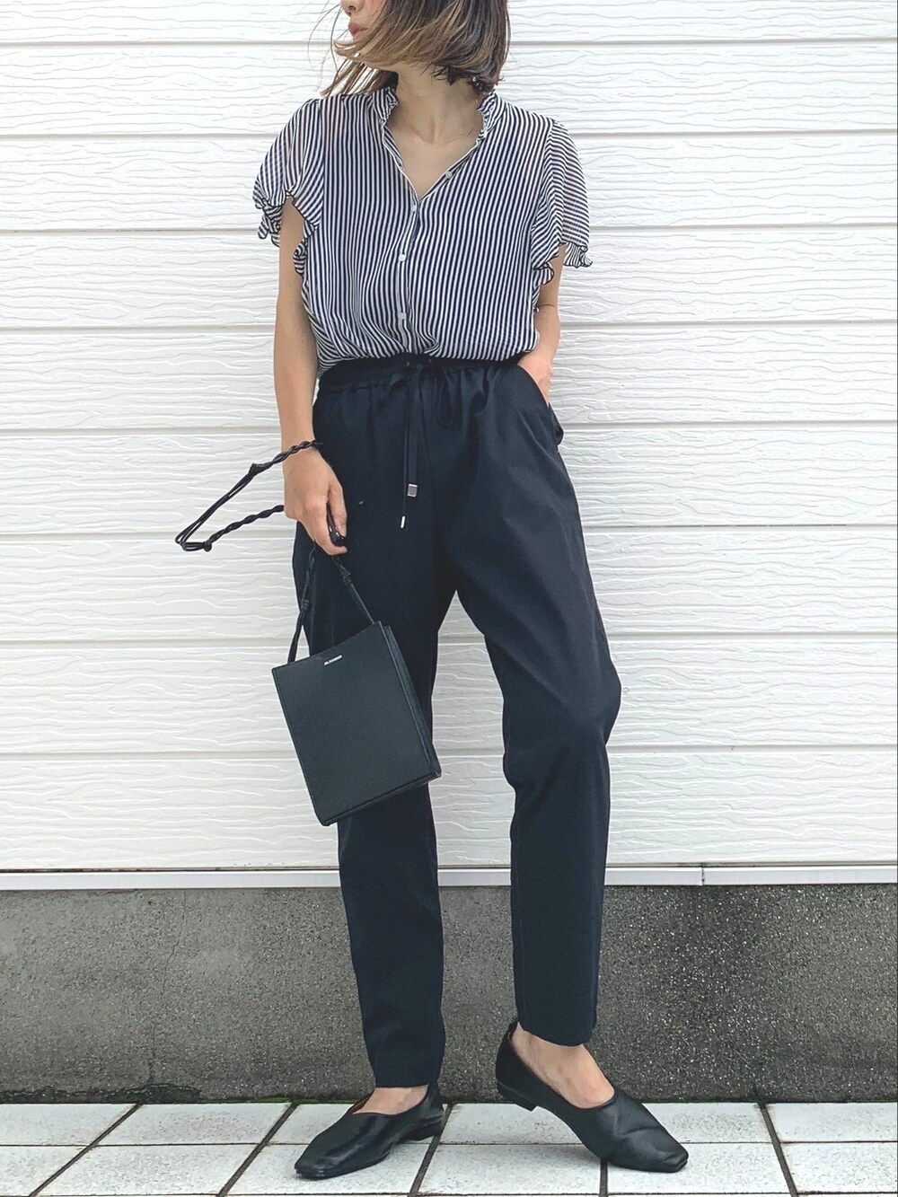 ブラック系のショルダーバッグ、ブラック系のその他パンツ、ブルー系のシャツ/ブラウスを着用したレディースの夏コーディネートの2枚目の写真