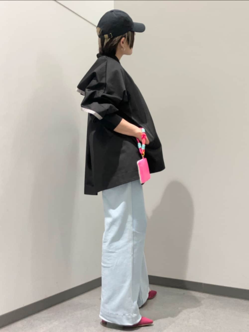 ブルー系のデニムパンツ、ブラック系のブルゾン、ブラック系のキャップを着用したレディースの春コーディネートの2枚目の写真