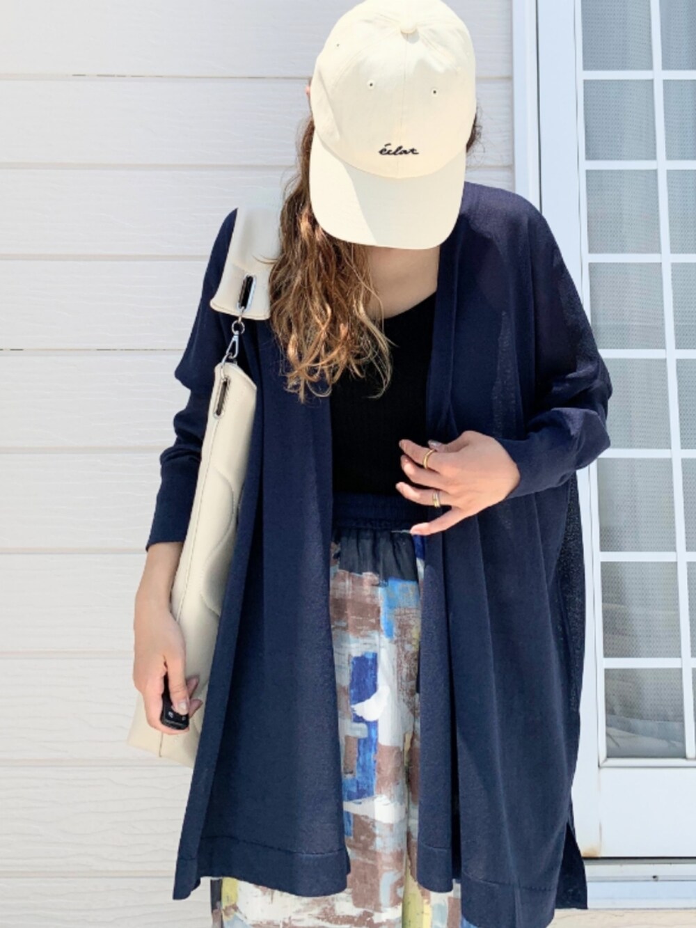 ブルー系のその他パンツ、ホワイト系のハンドバッグ、ブラック系のキャミソールを着用したレディースの夏コーディネートの5枚目の写真