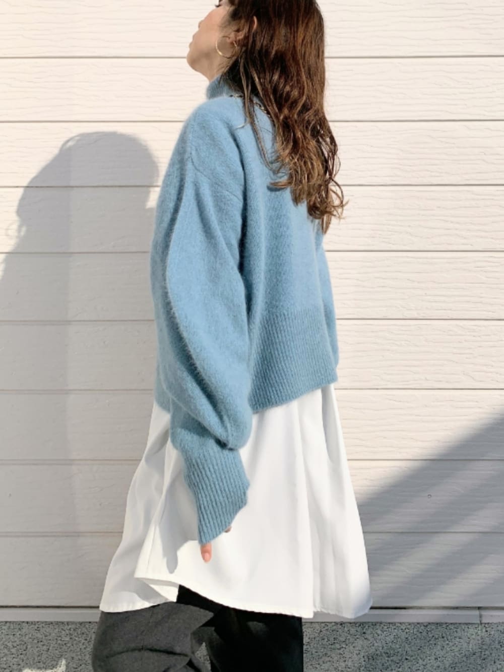 グレー系のその他パンツ、ホワイト系のスニーカー、ブルー系のニット/セーターを着用したレディースの冬コーディネートの4枚目の写真