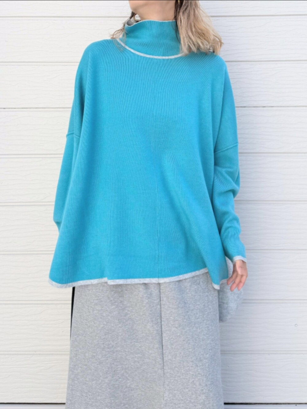 グレー系のニット/セーター、グレー系のスカート、ブラック系のキャップを着用したレディースの秋コーディネートの4枚目の写真