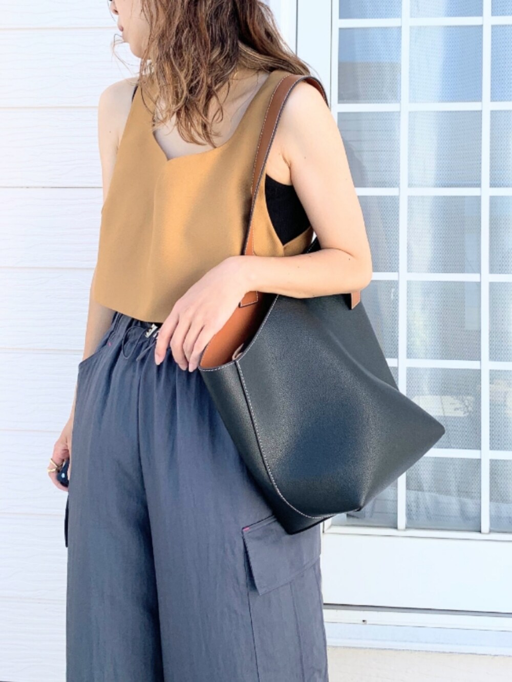 グレー系のその他パンツ、イエロー系のベスト、ブラック系のショルダーバッグを着用したレディースの夏コーディネートの4枚目の写真