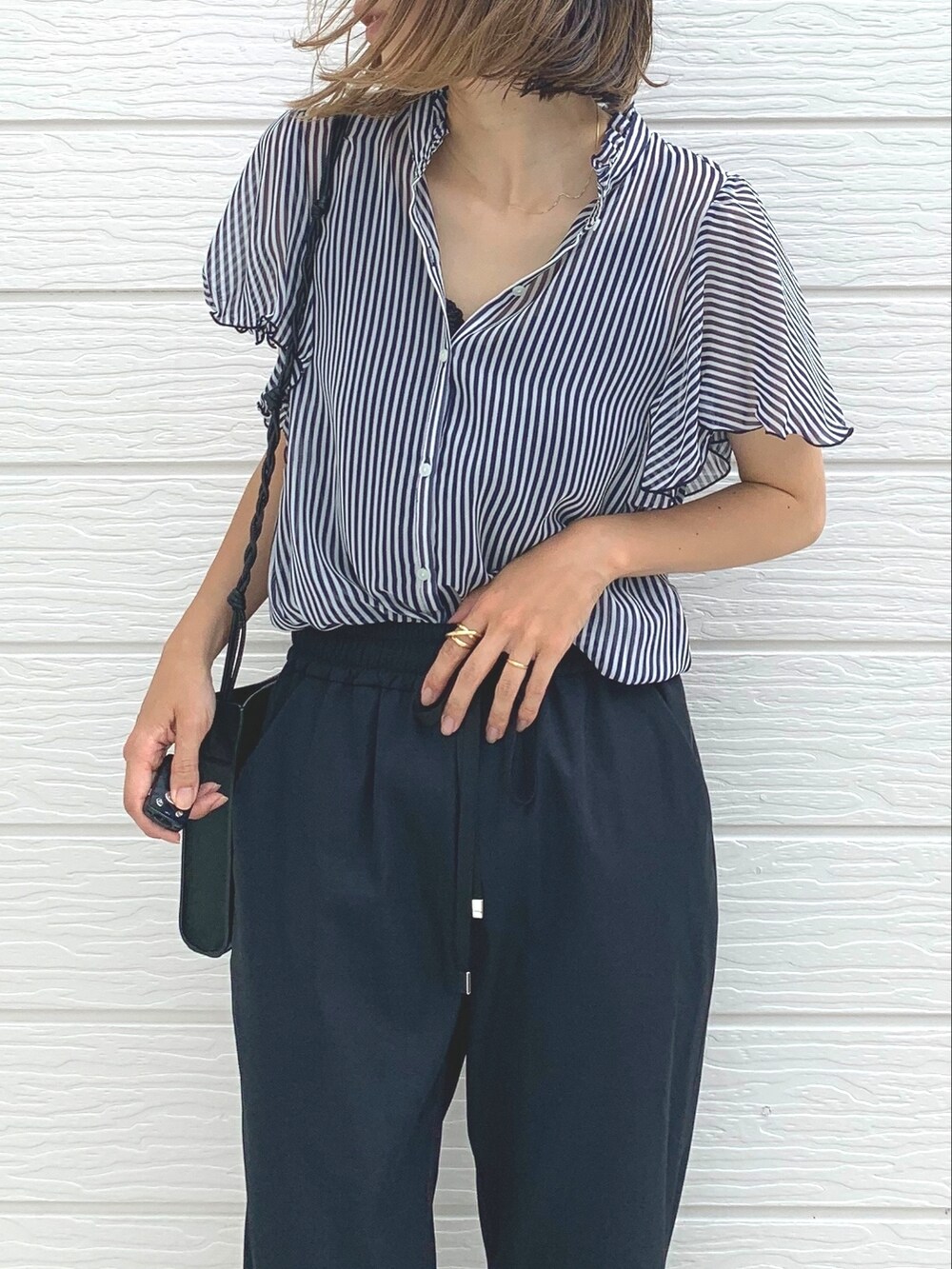 ブラック系のショルダーバッグ、ブラック系のその他パンツ、ブルー系のシャツ/ブラウスを着用したレディースの夏コーディネートの3枚目の写真