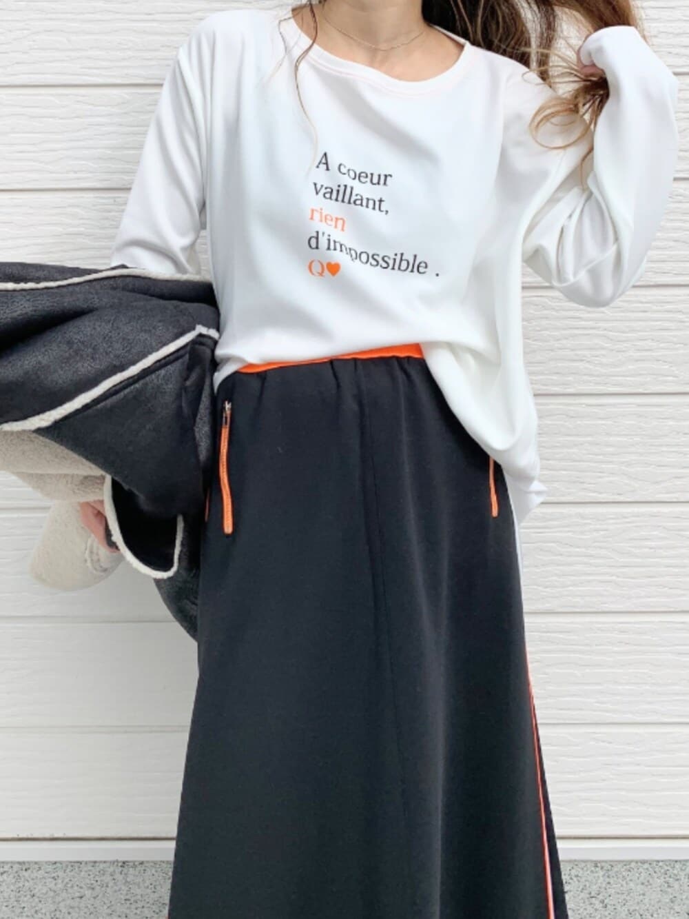 ゴールド系のスカート、ブラウン系のブーツ、ホワイト系のTシャツ/カットソーを着用したレディースの秋コーディネートの4枚目の写真