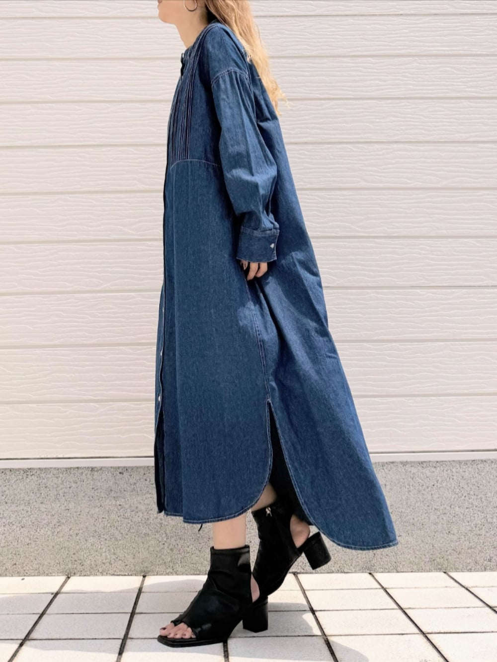 ブラック系のサンダル、ブルー系のシャツワンピース、ベージュ系のハンドバッグを着用したレディースの夏コーディネートの2枚目の写真