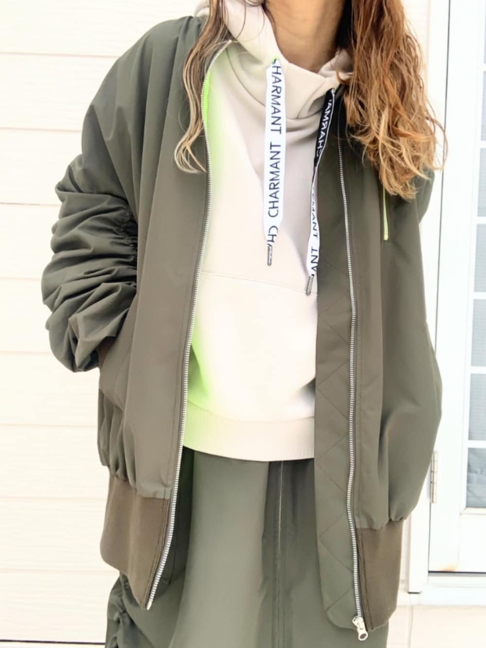 ブラウン系のブーツ、グリーン系のMA-1、グリーン系のスカートを着用したレディースの夏コーディネートの4枚目の写真