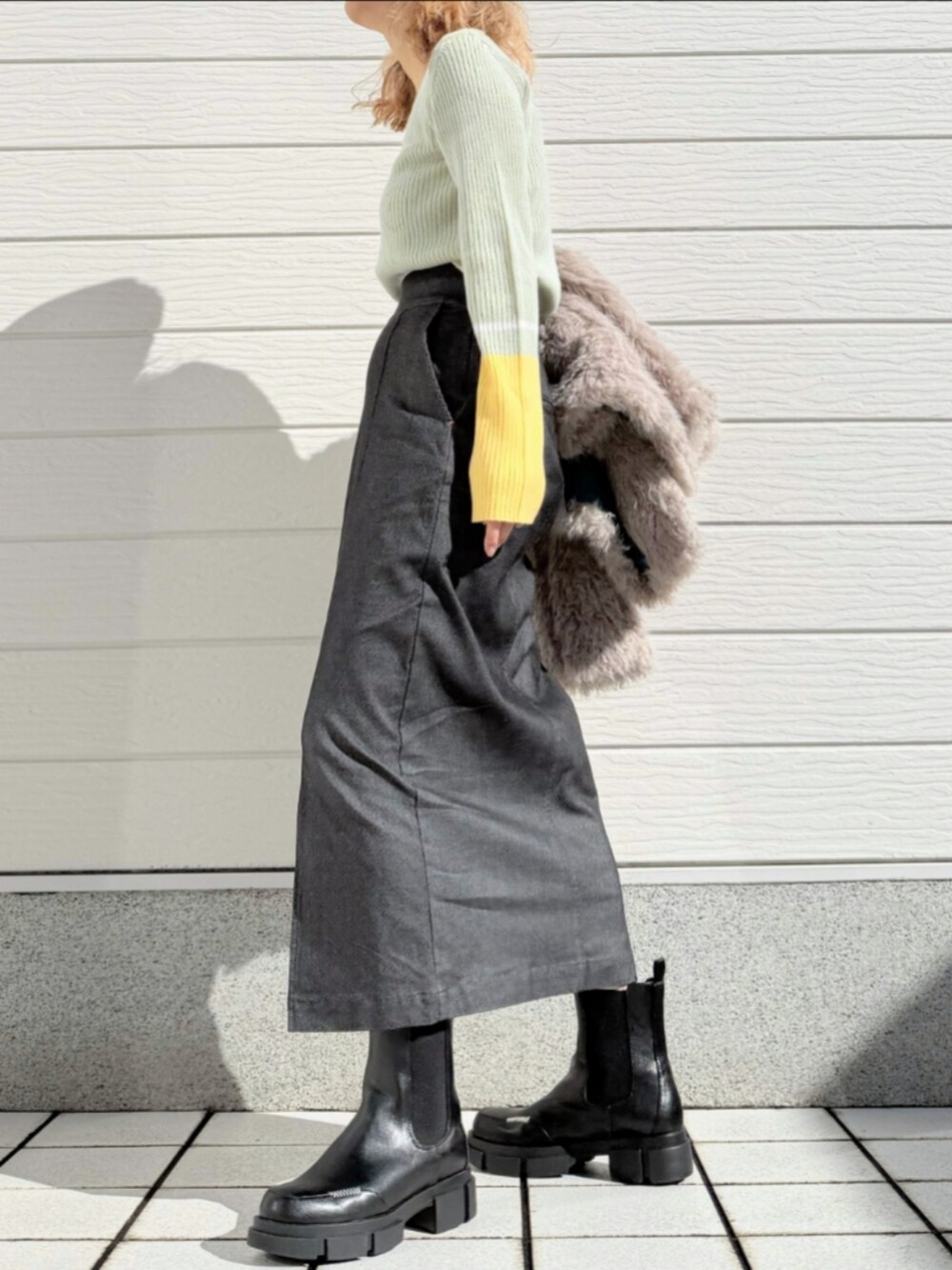 ブラック系のブーツ、ベージュ系のノーカラーコート、グレー系のニット/セーターを着用したレディースの秋コーディネートの3枚目の写真