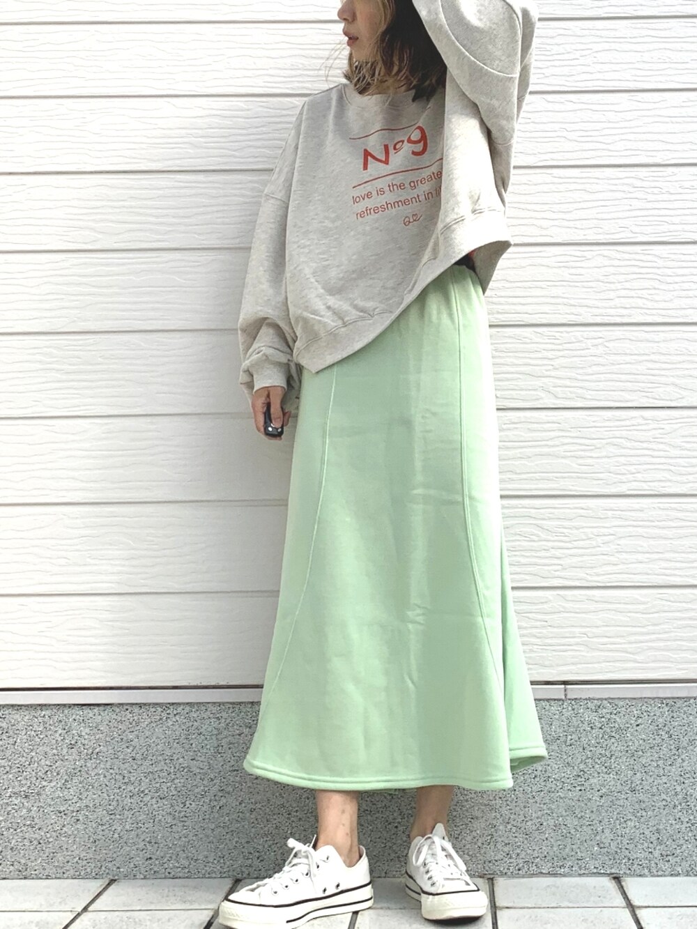 グリーン系のスカート、グレー系のスウェット、ホワイト系のスニーカーを着用したレディースの冬コーディネートの2枚目の写真