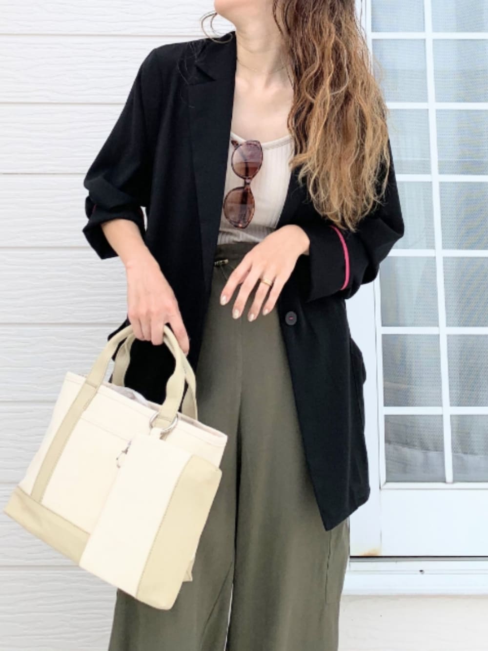 グリーン系のカーゴパンツ、ベージュ系のトートバッグ、ベージュ系のキャミソールを着用したレディースの夏コーディネートの4枚目の写真