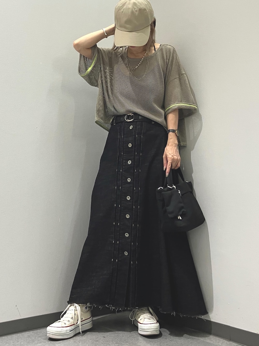 グリーン系のTシャツ/カットソー、ブラック系のデニムスカート、ブラック系のショルダーバッグを着用したレディースの夏コーディネートの3枚目の写真