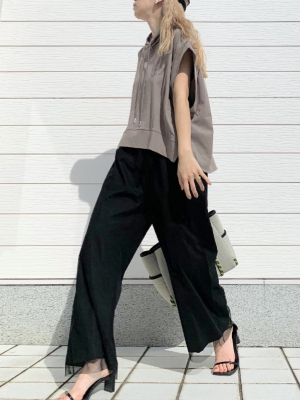 ブラック系のその他パンツ、グレー系のトートバッグ、グリーン系のパーカーを着用したレディースの春コーディネートの2枚目の写真