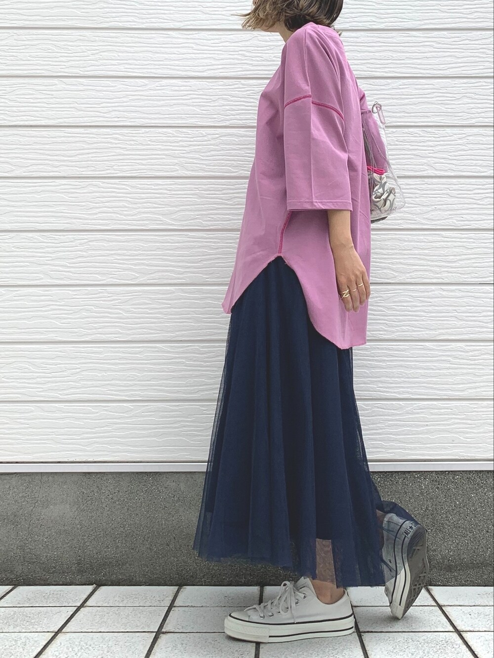 ブルー系のスカート、ホワイト系のスニーカー、パープル系のTシャツ/カットソーを着用したレディースの夏コーディネートの2枚目の写真