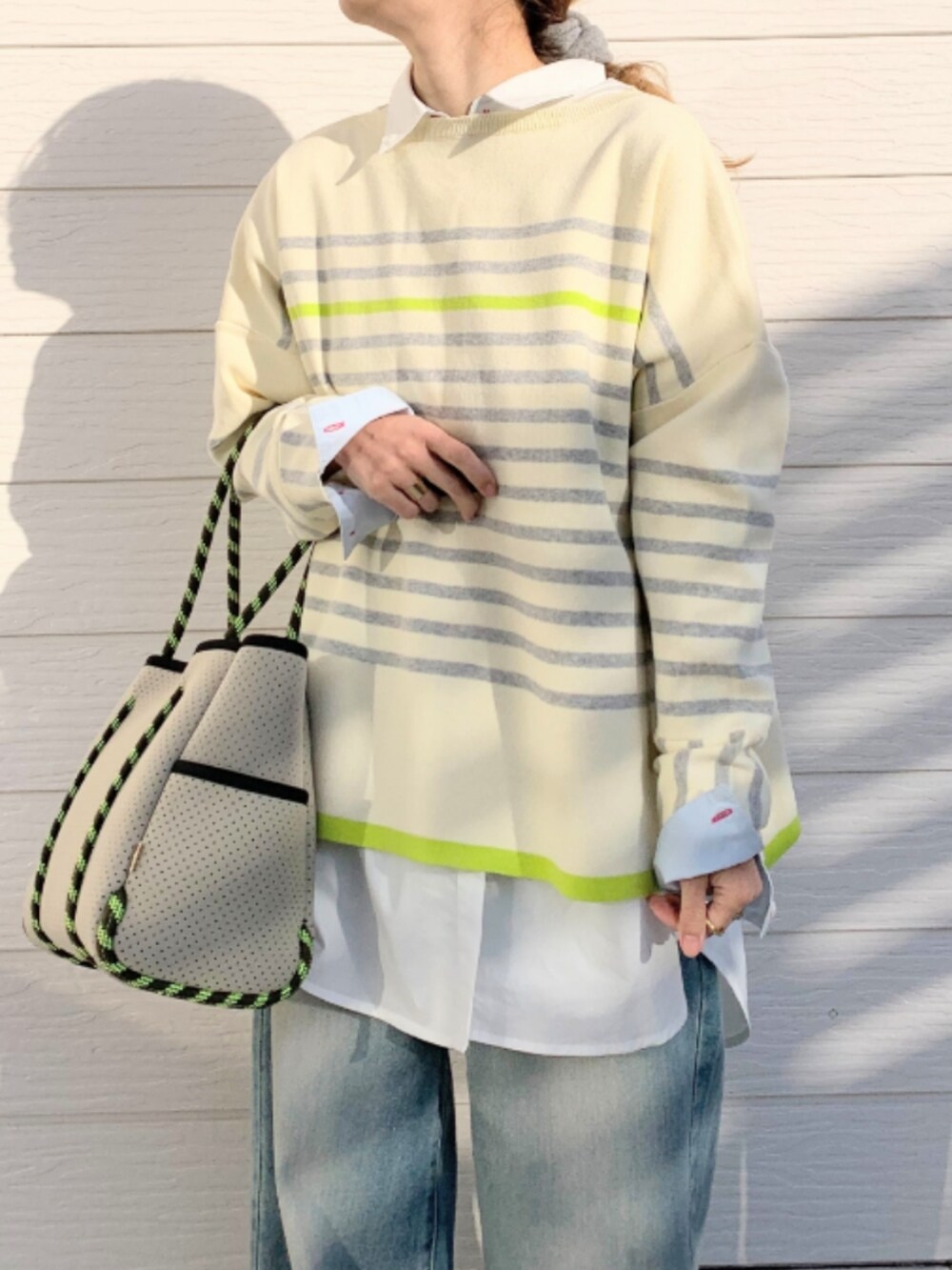 ブルー系のデニムパンツ、ホワイト系のシャツ/ブラウス、グレー系のトートバッグを着用したレディースの冬コーディネートの2枚目の写真