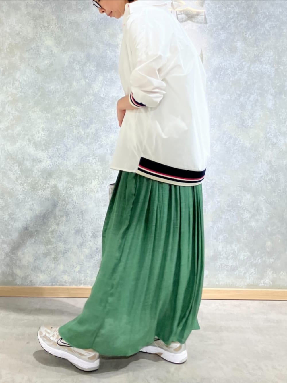 シルバー系のトートバッグ、グリーン系のスカート、ホワイト系のTシャツ/カットソーを着用したレディースの秋コーディネートの3枚目の写真