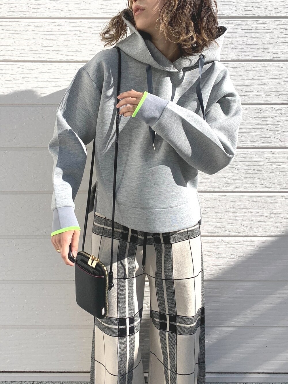 ブラック系のショルダーバッグ、グレー系のパーカー、ホワイト系のその他パンツを着用したレディースの冬コーディネートの4枚目の写真