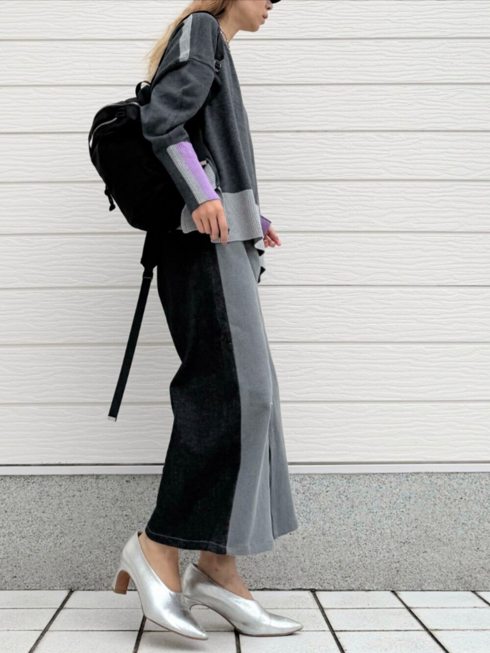 ブラック系のデニムパンツ、グレー系のニット/セーター、ブラック系のバックパック/リュックを着用したレディースの秋コーディネートの2枚目の写真