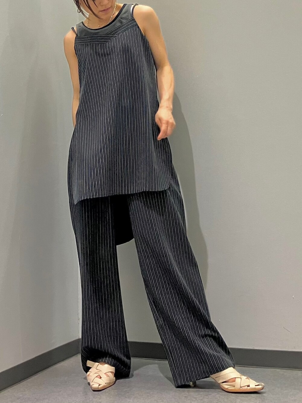 ブラック系のスラックス、ブラック系のタンクトップ、ブラック系のチュニックを着用したレディースの夏コーディネートの2枚目の写真