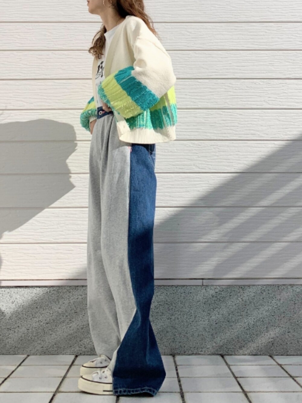 グレー系のデニムパンツ、ホワイト系のスニーカー、ホワイト系のTシャツ/カットソーを着用したレディースの冬コーディネートの2枚目の写真