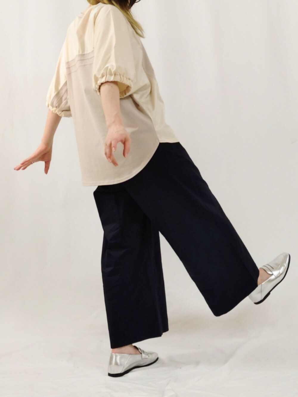 ブルー系のスラックス、シルバー系のローファー、ベージュ系のTシャツ/カットソーを着用したレディースの春コーディネートの3枚目の写真