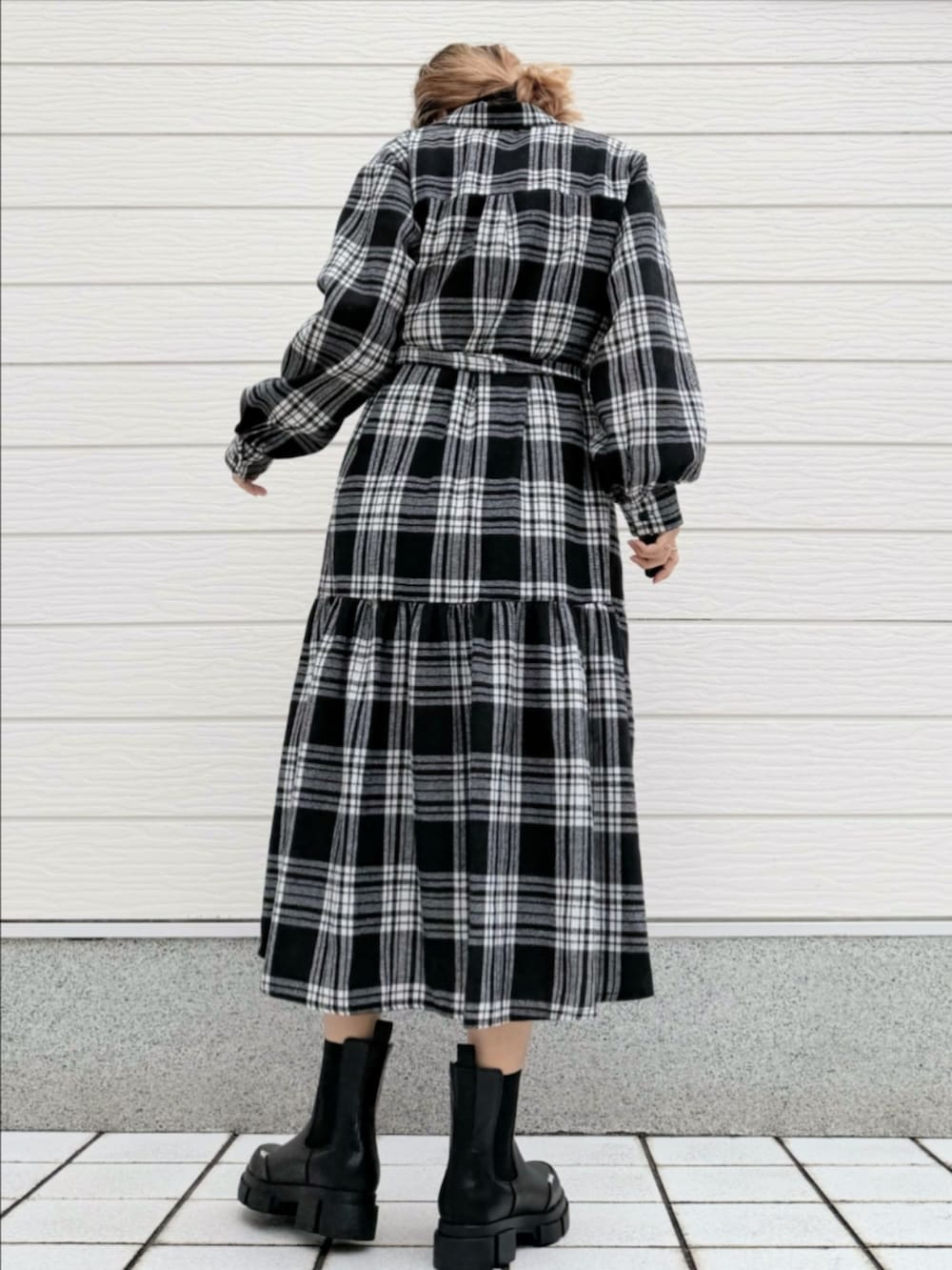 ブラック系のブーツ、ブラック系のシャツワンピース、ホワイト系のTシャツ/カットソーを着用したレディースの秋コーディネートの2枚目の写真