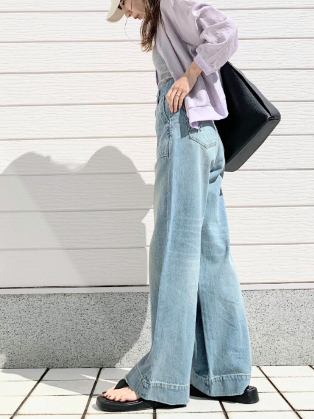 グレー系のキャミソール、グレー系のブルゾン、ブルー系のデニムパンツを着用したレディースの春コーディネートの2枚目の写真
