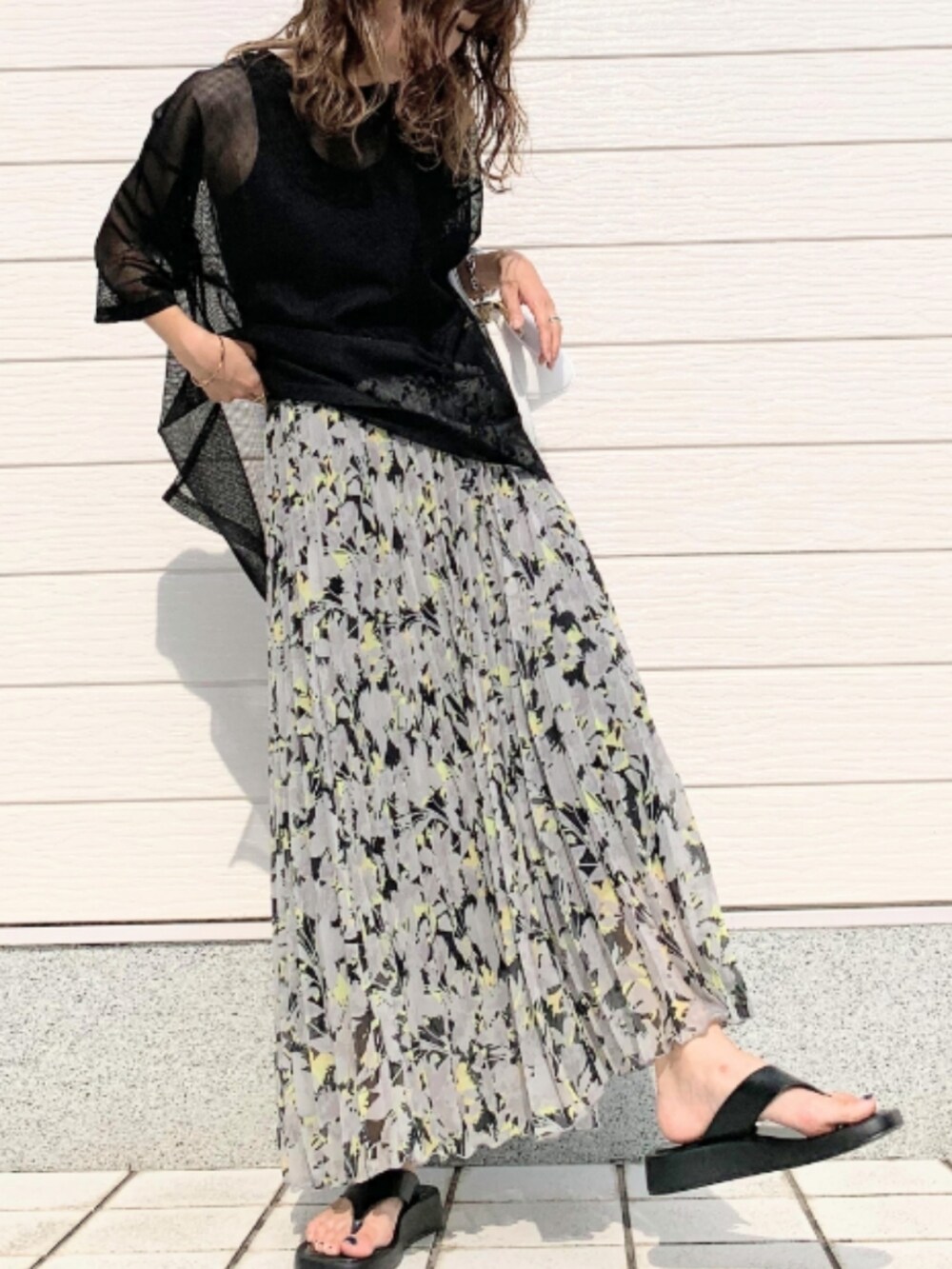 ブラック系のスカート、ホワイト系のショルダーバッグ、ブラック系のTシャツ/カットソーを着用したレディースの夏コーディネートの2枚目の写真